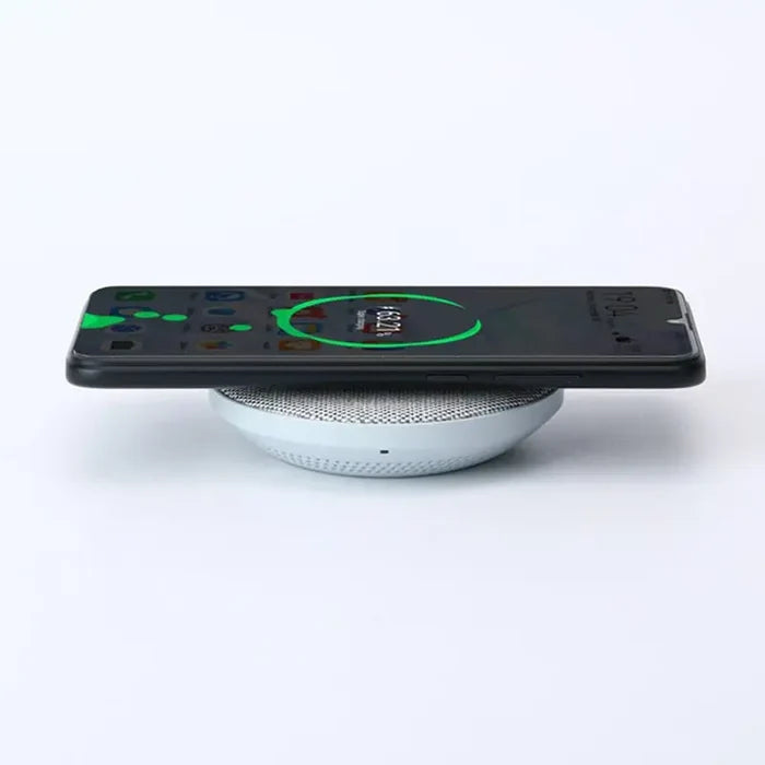 a white phone with a green light on it
