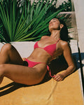 Front view of a model sunbathing outdoors wearing the LSPACE Aspen Bikini Top and Levy Bikini Bottom.