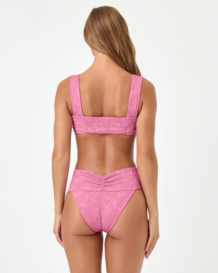 Back view of a model wearing the LSPACE hottest pink Bardot Bikini Bottom with a matching Marlee bikini top.