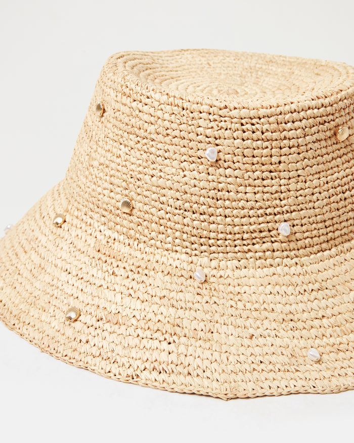 Close-up of the Carmel Island Hat in natural showing the woven raffia texture and scattered pearl and gold bead embellishments.