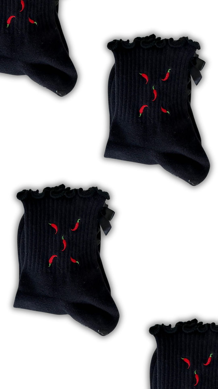 Black ruffle non slip grip sock with red chili pepper embroidered on them and black heart grips and a black bow