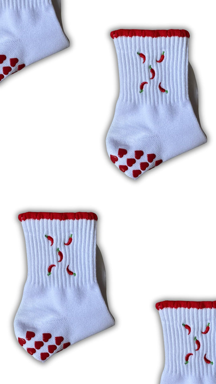 Red and white non slip grip socks with chilies embordered on them and red heart grips
