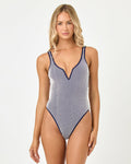 Front view of a model wearing the LSPACE midnight blue Coco One Piece Swimsuit with a V-neckline, vertical stripe pattern, and midnight blue trim.