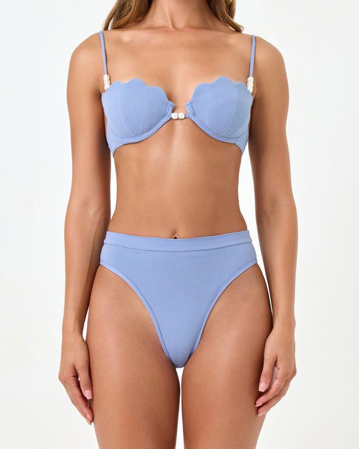 Close-up front view of a model wearing the LSPACE chambray Sunrise Shell Bikini Top and Frenchi Bikini Bottom highlighting the wide waistband and high-cut leg opening.