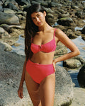 Front view of a model standing on a rocky coastline wearing the LSPACE pout Hunter Bikini Top with underwire cups and U-notch neckline paired with the Soleil Bikini Bottom.