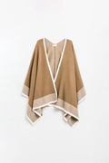 Knitted poncho in camel with ecru trim