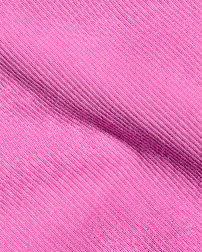 A close-up of bright pink ribbed fabric.