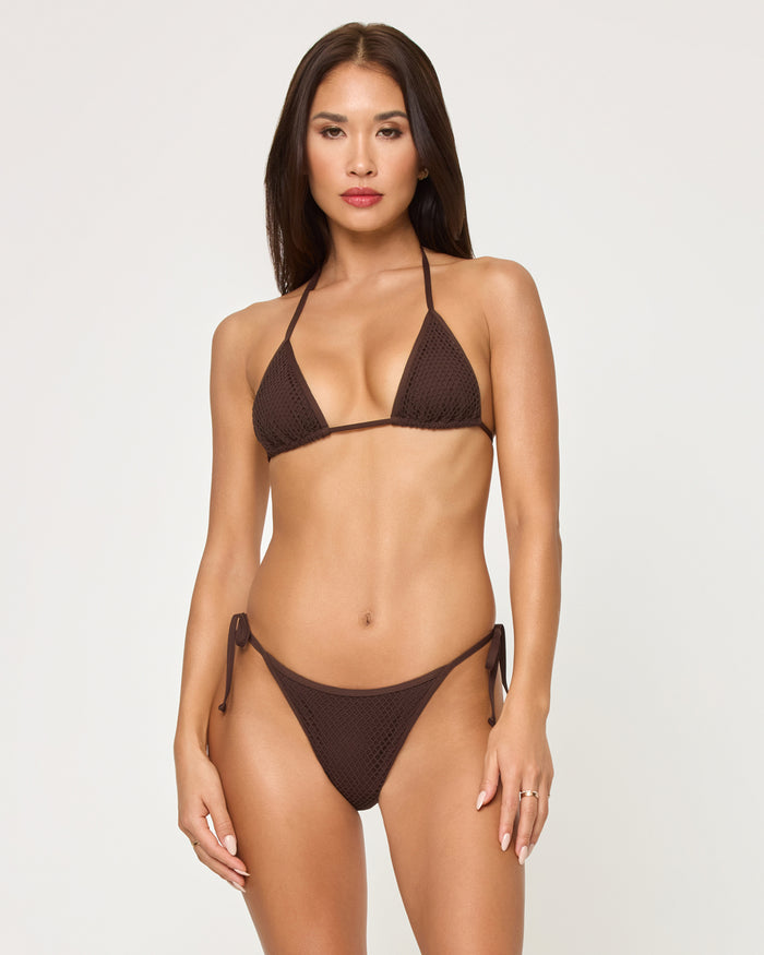 Front view of a model wearing the LSPACE espresso Levy Bikini Bottom with a crochet mesh texture and side tie detail, paired with a matching espresso triangle Aspen Bikini Top.