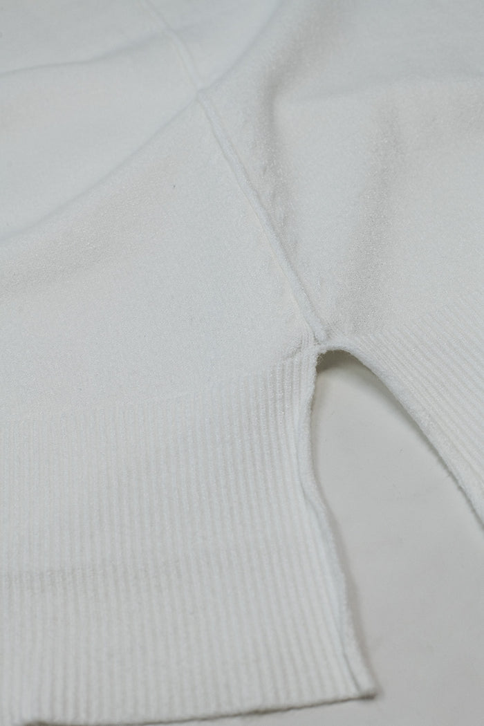 Loose white sweater with open back detail