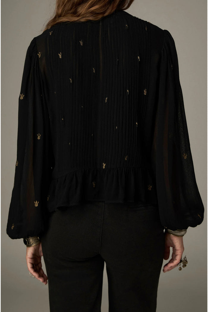 Shop the Maison Hotel Catherine Blouse in Blackout at Dotique. An embroidered black blouse with a cropped shape, ruffled hem and mother-of-pearl buttons.