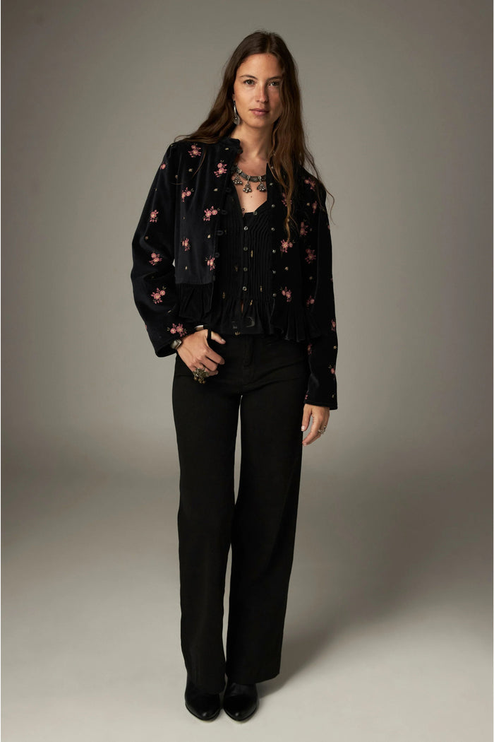 Shop the Maison Hotel Catherine Blouse in Blackout at Dotique. An embroidered black blouse with a cropped shape, ruffled hem and mother-of-pearl buttons.