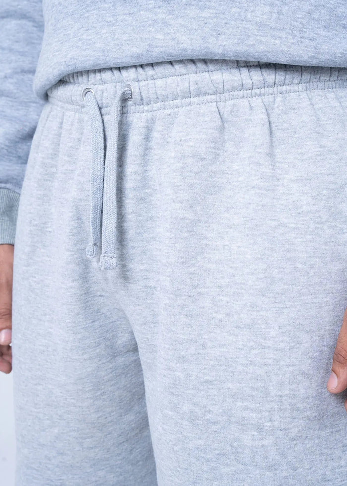Light grey fleece shorts close-up: elastic waist with drawstring and stitched hem