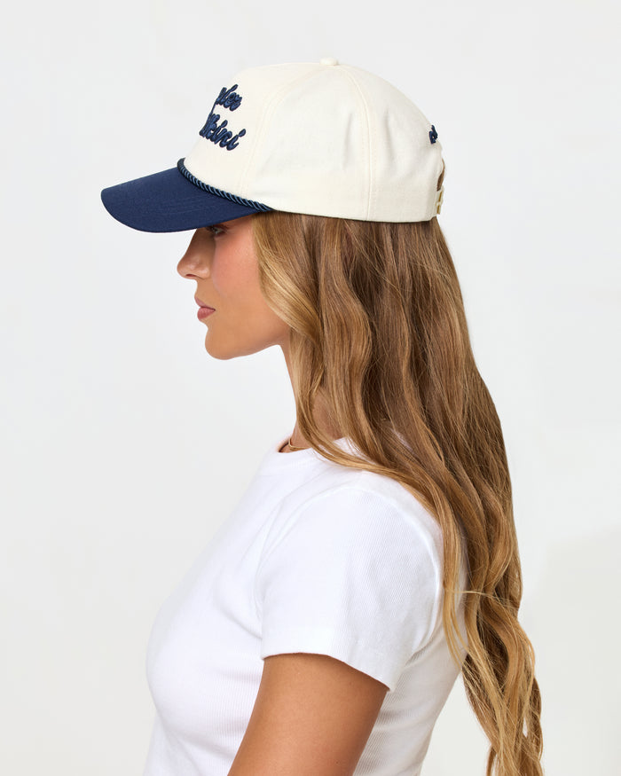 Side profile view of a model wearing the midnight cream Newport Hat.