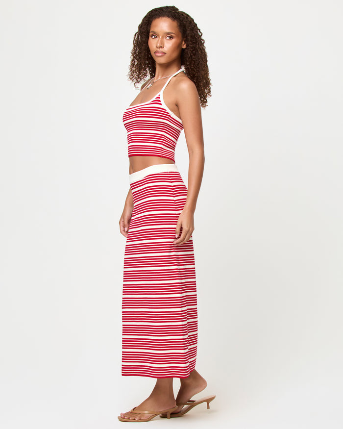Side view of a model wearing the LSPACE Positano Top and Ravello Skirt in superbloom stripe, a fitted ribbed fabric with red and cream horizontal stripes.