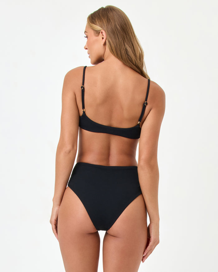 Back view of a model wearing the LSPACE black Presley Bikini Top with adjustable straps and gold ring hardware, styled with the matching Soleil Bikini Bottom.