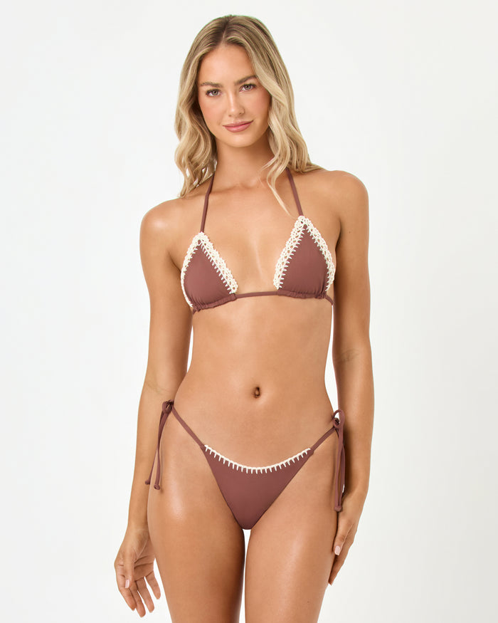 Front view of a model wearing the LSPACE cafe Samba Bikini Top with cream crochet trim and matching tie-side bikini bottom.