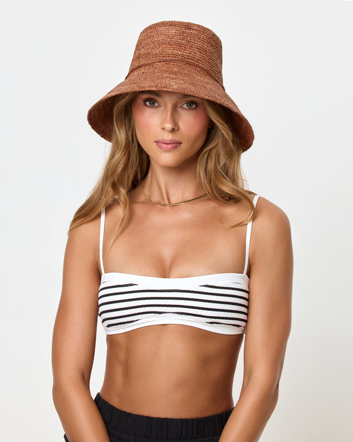 Front view of a model wearing the brown Seville Hat with a white and black striped bikini top and black shorts.