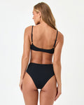 Back view of a model wearing the LSPACE black Soleil Bikini Bottom with the Presley Bikini Top.