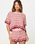 Close-up front view of model wearing the LSPACE Sunchaser Top and Short in berry spritz showing the wave crochet pattern and scalloped hem detail.