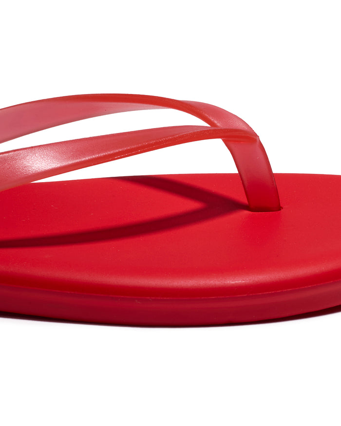 Close-up of the red thong strap and footbed detail on the TKEES Aqua Sandals.