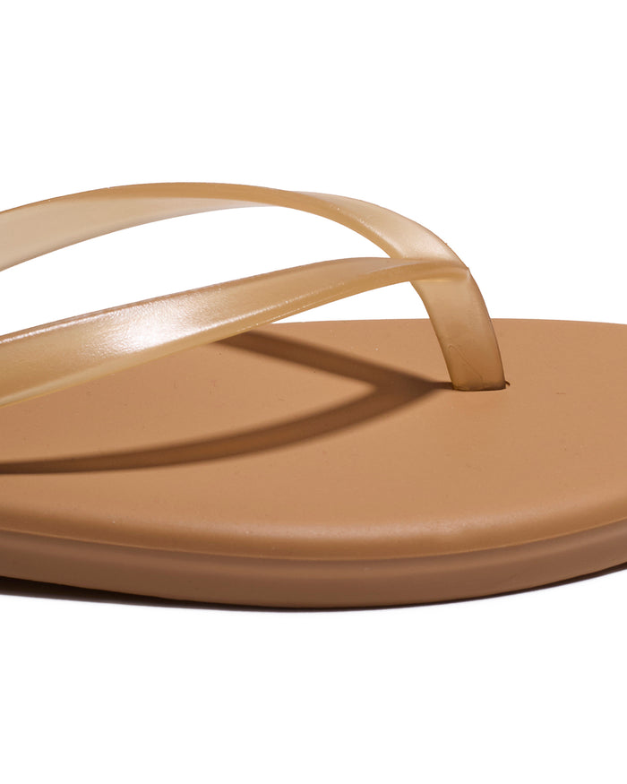 Close-up of the tan leather thong strap and footbed detail on the TKEES Aqua Sandals.