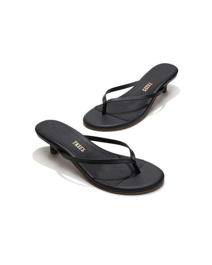 Angled view of both black sable leather TKEES Julia Kitten Heel thong sandals with TKEES logo.