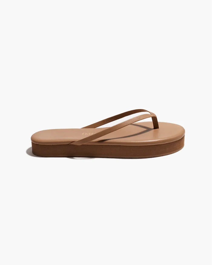 Side view of a single cocobutter TKEES Lily Platform Sandal showing the platform heel height.