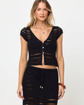 Front view of model wearing the LSPACE Tula Top in black, a semi-sheer crochet cropped top with cap sleeves and button front, styled with matching black crochet maxi skirt.